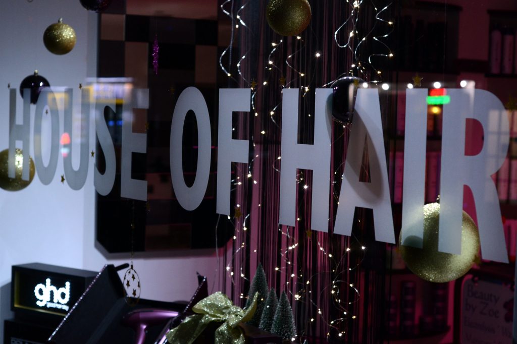House of Hair Honiton hair salon window sign with christmas lights and decorations