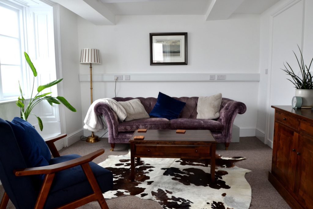 Heart Felt Trauma Therapy room with comfortable sofa, coffee table and black/white rug on floor